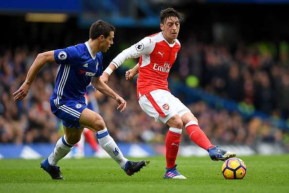 LONDON, ENGLAND - FEBRUARY 04:  Mesut Oezil of Arsenal passes the ball under pressure from Cesar Azpilicueta of Chelsea during the Premier League match between Chelsea and Arsenal at Stamford Bridge on February 4, 2017 in London, England.  (Photo by Mike Hewitt/Getty Images)