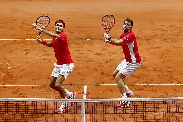 LILLE, FRANCE - NOVEMBER 22:  Roger Federer of Switzerland and Stanislas Wawrinka of Switzerland in action against Richard Gasquet of France and Julien Benneteau of France in the doubles during day two of the Davis Cup Tennis Final between France and Switzerland at the Stade Pierre Mauroy on November 22, 2014 in Lille, France.  (Photo by Julian Finney/Getty Images)