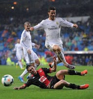 MADRID, SPAIN - MARCH 29: Cristiano Ronaldo (R) of Real Madrid FC is tackled by Borja Lopez of Rayo Vallecano de Madrid during the La Liga match between Real Madrid CF and Rayo Vallecano de Madrid at Santiago Bernabeu stadium on March 29, 2014 in Madrid, Spain. (Photo by Denis Doyle/Getty Images)