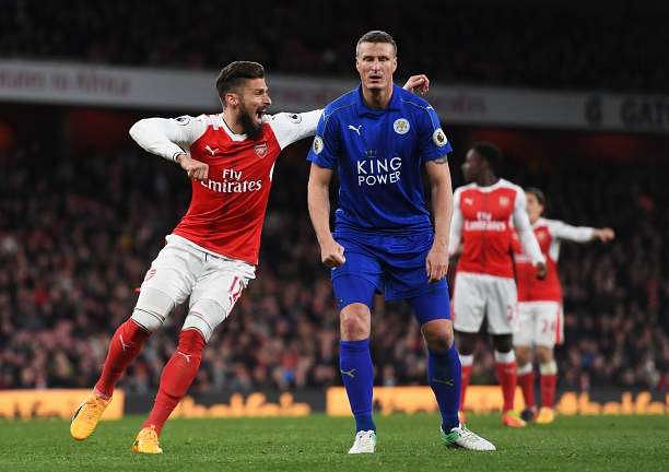 LONDON, ENGLAND - APRIL 26: Olivier Giroud of Arsenal celebrates as Robert Huth of Leicester City looks dejected after he scores an own goal during the Premier League match between Arsenal and Leicester City at the Emirates Stadium on April 26, 2017 in London, England.  (Photo by Shaun Botterill/Getty Images)