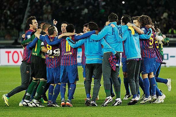 YOKOHAMA, JAPAN - DECEMBER 18:  Lionel Messi (just seen centre) of Barcelona celebrates with team mates after victory in the FIFA Club World Cup Final match between Santos and FC Barcelona at the International Yokohama Stadium on December 18, 2011 in Yokohama, Japan.  (Photo by Lintao Zhang/Getty Images)
